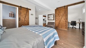 Un dormitorio con cama, escritorio y silla. Cuenta con una puerta corrediza y un armario.