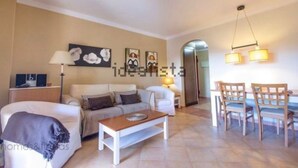 Un salon comprenant un canapé, une table basse et un coin repas avec des chaises.