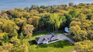 A house with a large yard and a view of the water. - Modern Home on Sand Point! 11 mins to DT caseville (Caseville)