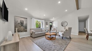 A modern living room with a sofa, armchairs, a coffee table, and artwork on the walls. - Modern Home on Sand Point! 11 mins to DT caseville (Caseville)