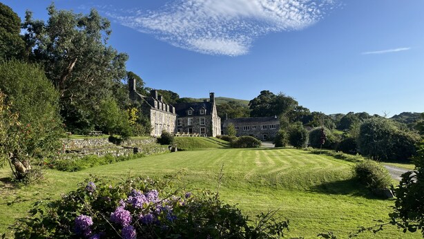 A large stone building with a well-maintained lawn and surrounding greenery. - Maes Y Neuadd Country House (Talsarnau)