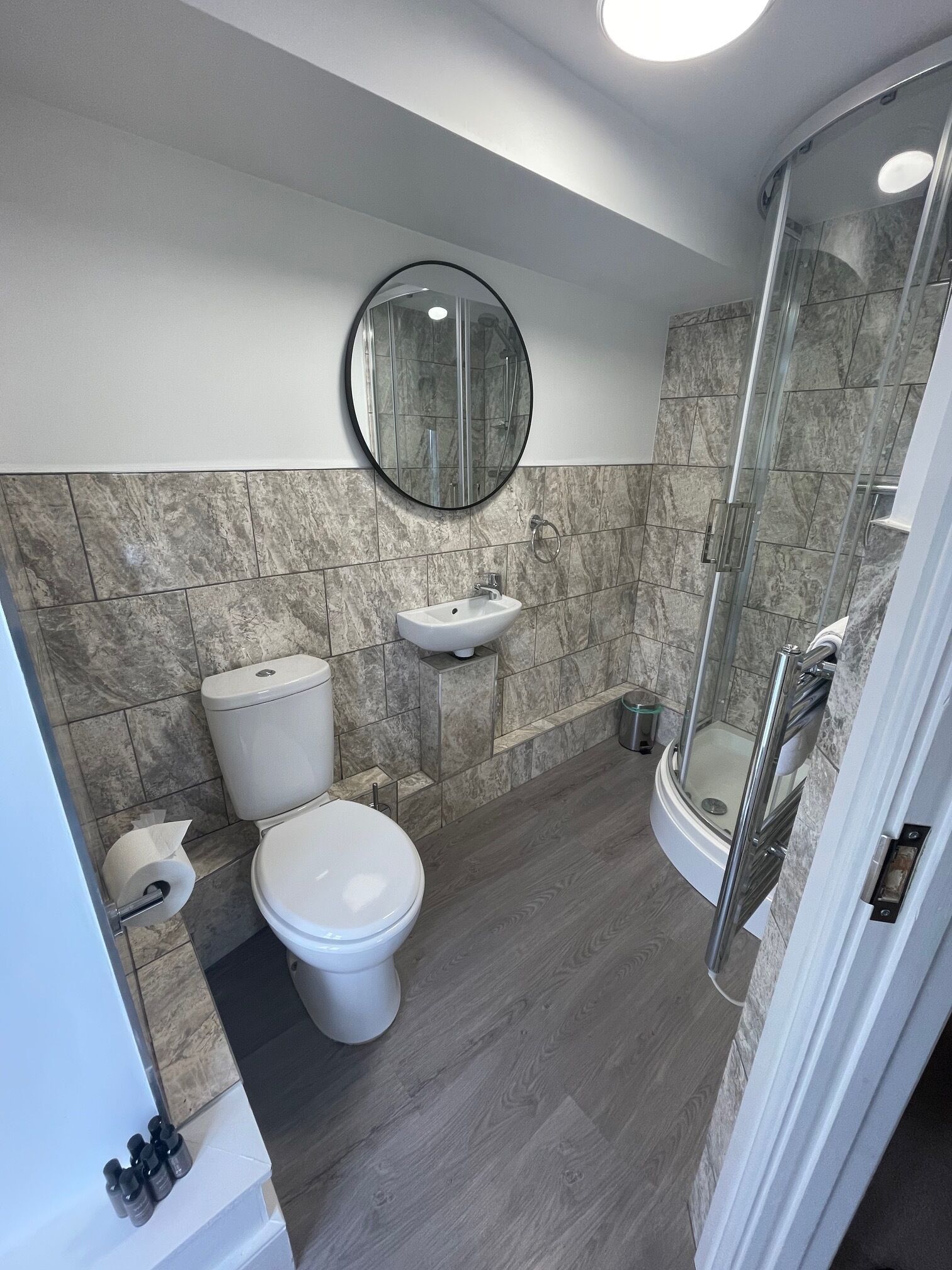 A modern bathroom with a toilet, sink, and glass shower enclosure.