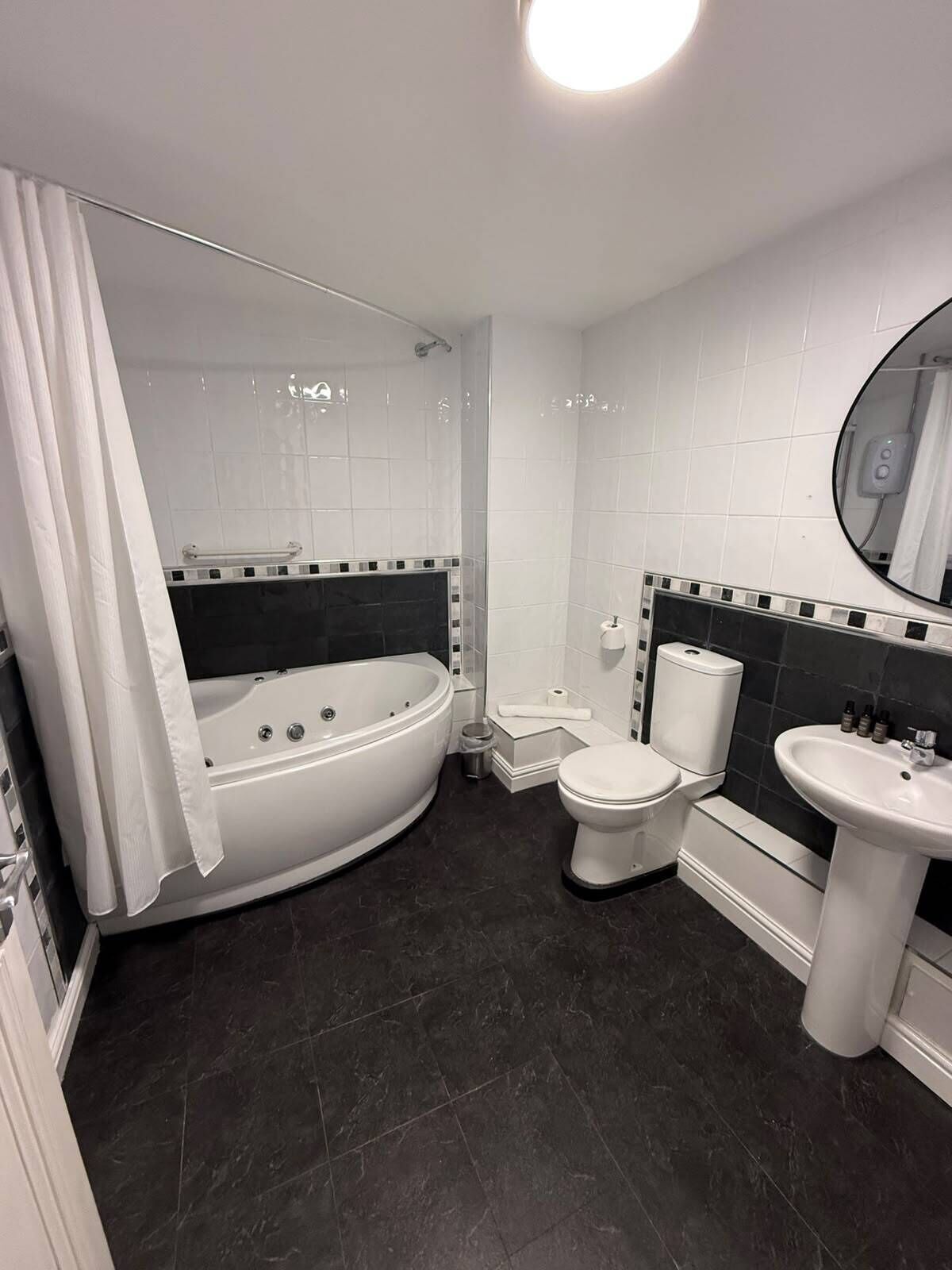 A modern bathroom with a freestanding bathtub, a toilet, and a sink.