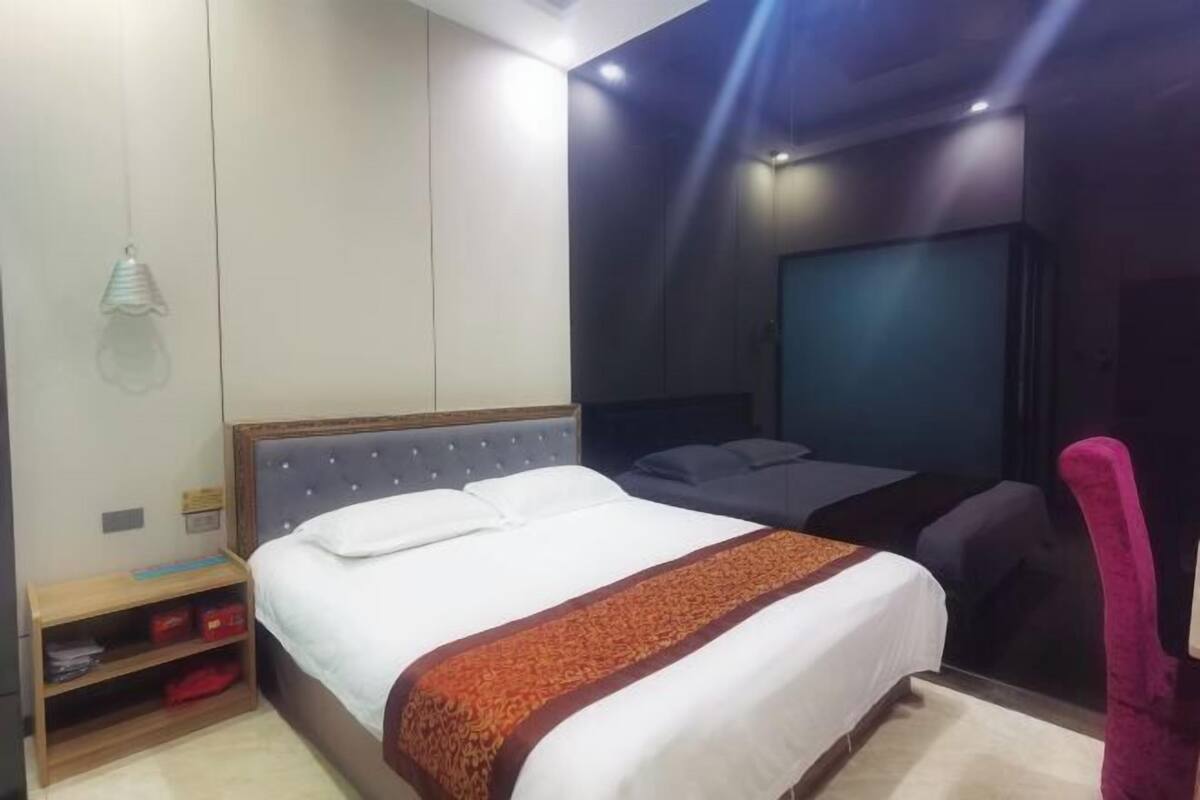 Una habitación de hotel moderna con una cama grande, un escritorio, una silla y un televisor.