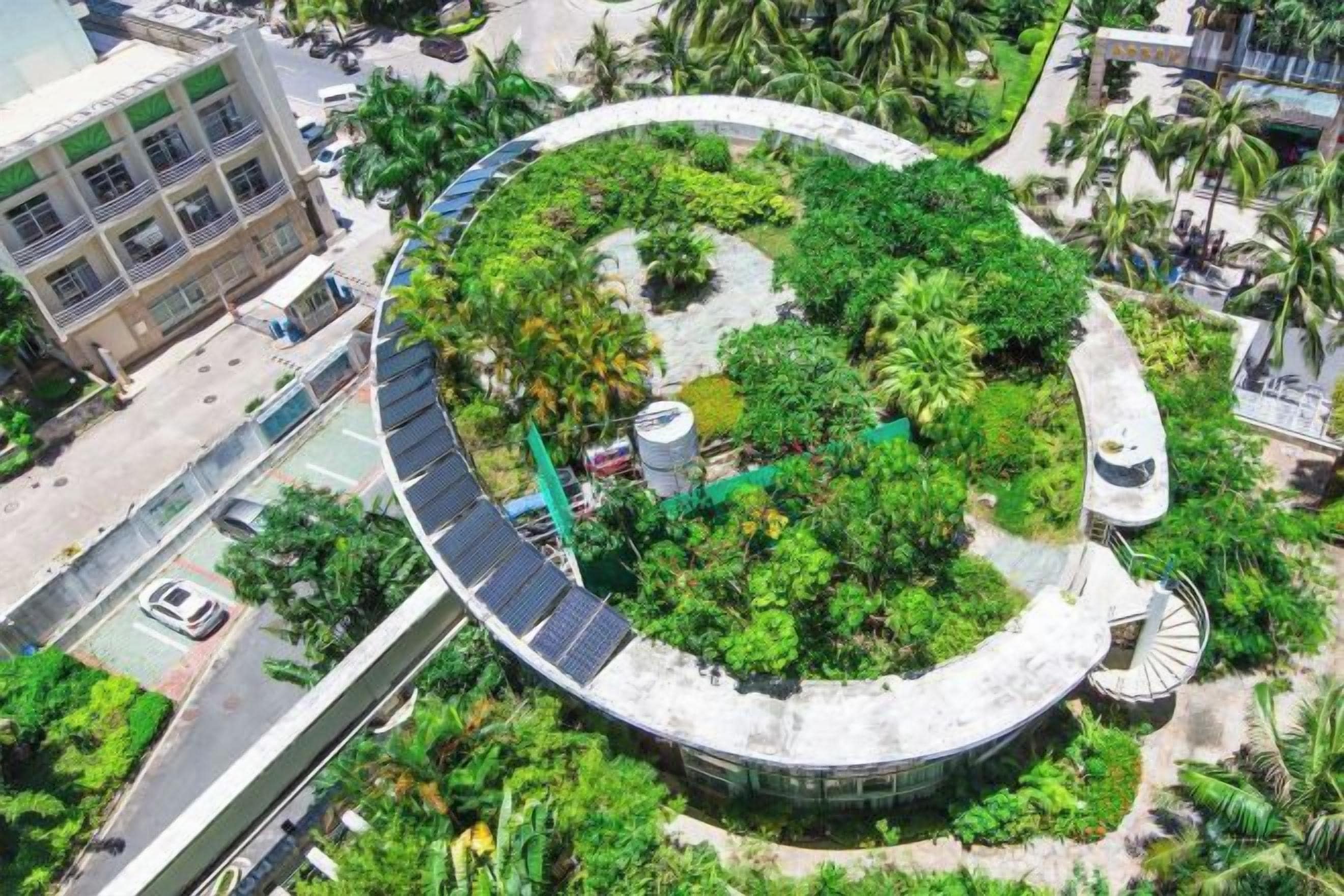 Un edificio circular con un jardín central, rodeado por un paseo curvo.