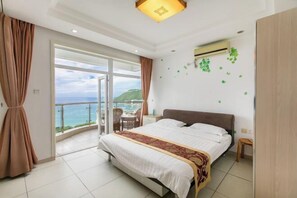 A bedroom with a bed, a balcony with a view, and an air conditioning unit. - Sanya Hai Hua Apartment (Sanya)