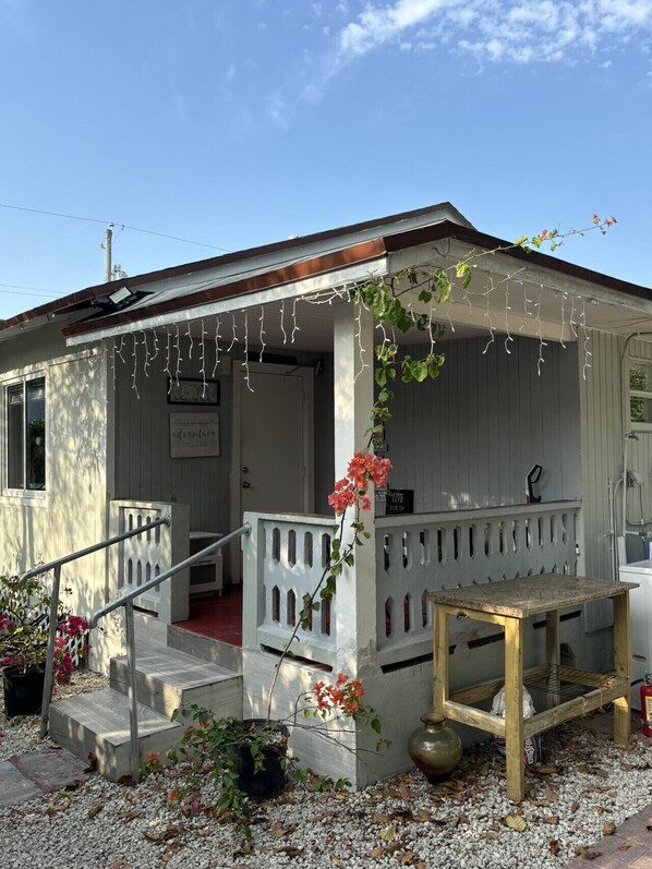 A small building with a porch, steps, a table, and a sign that says 'Live Every Day.'