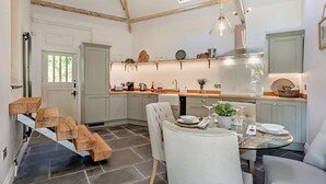 A modern kitchen with a dining area, featuring a central island, pendant lighting, and a view of the outdoors. - 2 Bed in Kelly (oc-k29333) (Kelly)