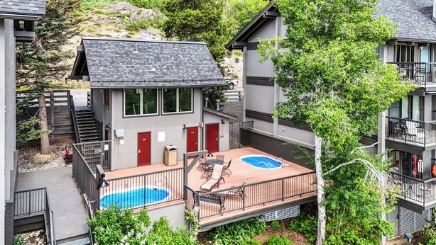 En boligbygning med en pool på taget, en trappe og et afspærret område med udendørs møbler.