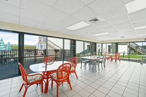 Un espace intérieur spacieux avec un balcon, de grandes fenêtres et un escalier menant à un niveau supérieur.