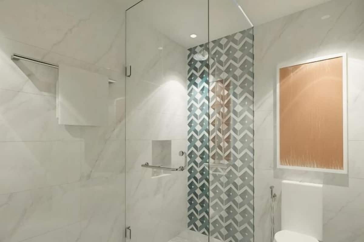 A modern bathroom with a glass shower enclosure, a mirror, and a toilet.