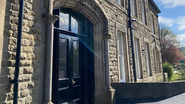 A stone building with a black door and arched windows. - The Matcham Studio in the heart of Buxton (Buxton)