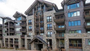 A multi-story hotel with stone facade, balconies, and large windows. - Modern 2 Bedroom Luxury Condo in Lionshead Village (Vail)