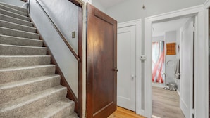 Una escalera con peldaños alfombrados que lleva a una puerta de madera.
