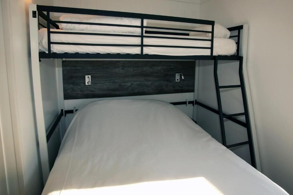 A bunk bed with a wooden headboard and a ladder.
