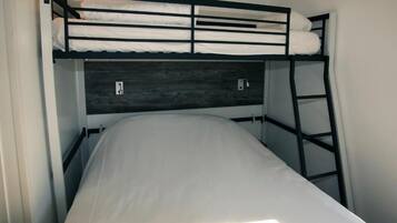 A bunk bed with a wooden headboard and a ladder.