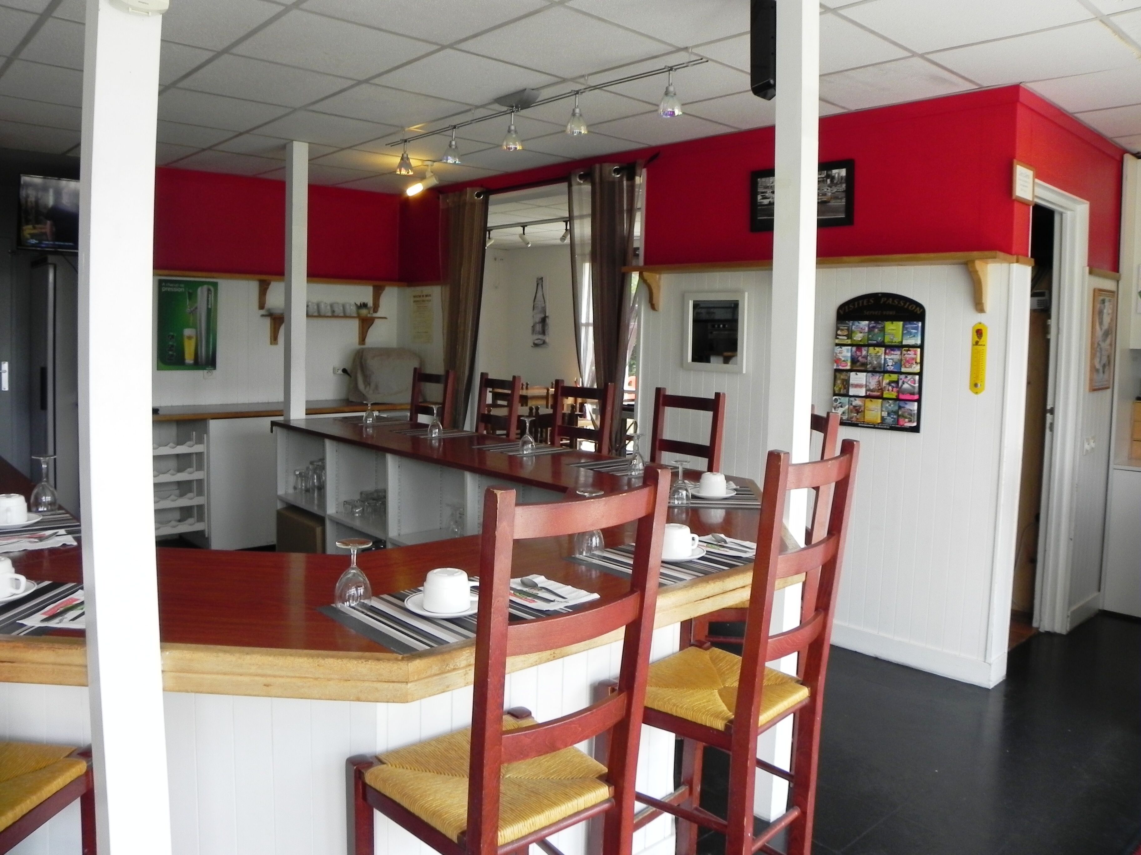 A dining area with a long wooden table, several chairs, and a mirror above the table.