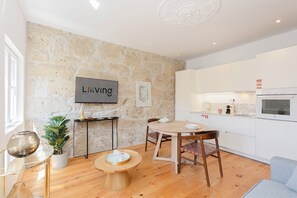 Enjoy a bright and airy living space with a flat-screen TV, oven, and dining area.