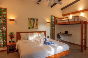 A bedroom with a bunk bed, a desk with a chair, a laptop, a decorative swan, and a painting on the wall.