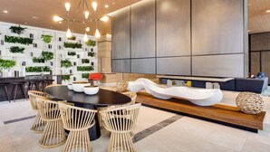 A modern dining area with a round table, wooden chairs, and a unique white bench. - Modern Condo 2bd/2bth, Best Brickell Location (Miami)