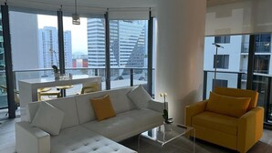 A modern living room with a white sofa, a yellow armchair, and a glass coffee table. - Modern Condo 2bd/2bth, Best Brickell Location (Miami)
