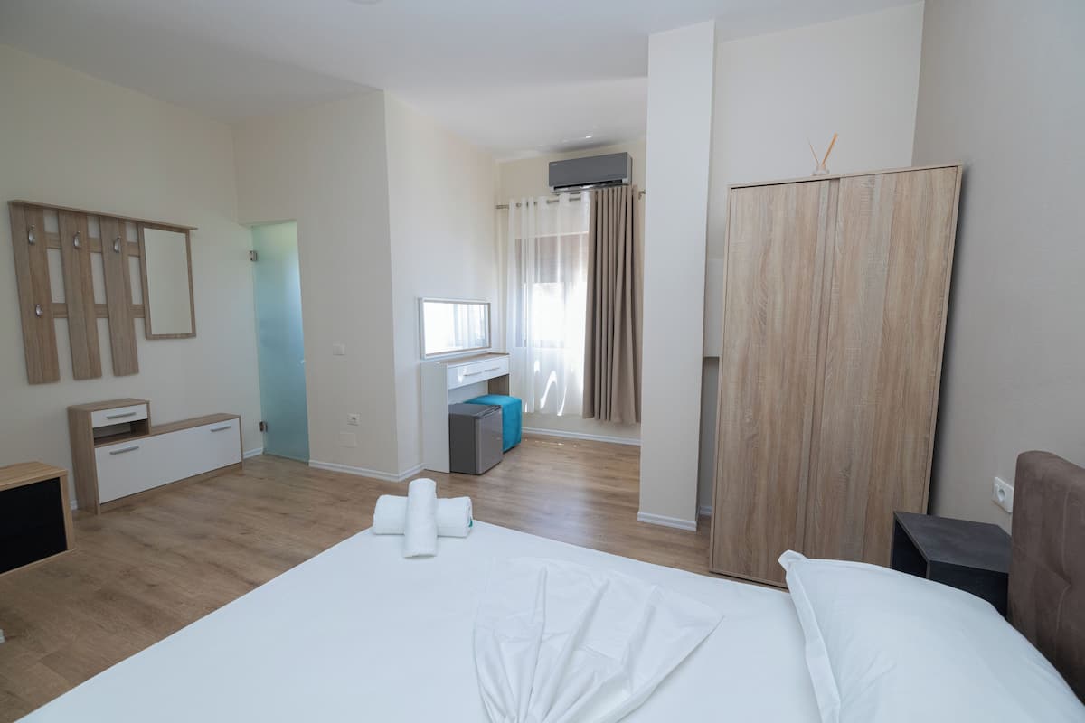 A hotel room with a bed, a desk, a wardrobe, and a bathroom.