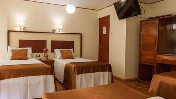 A hotel room with two beds, a TV, and a wardrobe.
