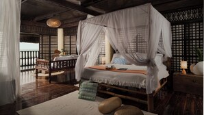 A room with a bed under a canopy, wooden flooring, and a view of the sea. - Serene beach front Villa near Vigan (San Juan)