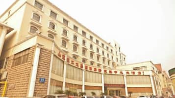 A multi-story hotel with a large parking lot in front.