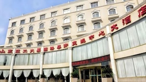A large hotel with multiple floors and a prominent entrance. - International Academic Exchange Center of Shandong University of Technology Hotel (Zibo)