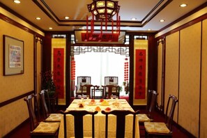 A traditional Chinese dining room with a table set for a meal, chairs, and a decorative lantern. - International Academic Exchange Center of Shandong University of Technology Hotel (Zibo)