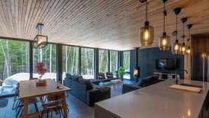 Un intérieur moderne avec un grand espace de vie à aire ouverte, une table à manger et un coin cuisine.