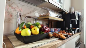 A kitchen counter with a fruit bowl, eggs, and a tray of pizza. - Vespucci Palace (Rome)