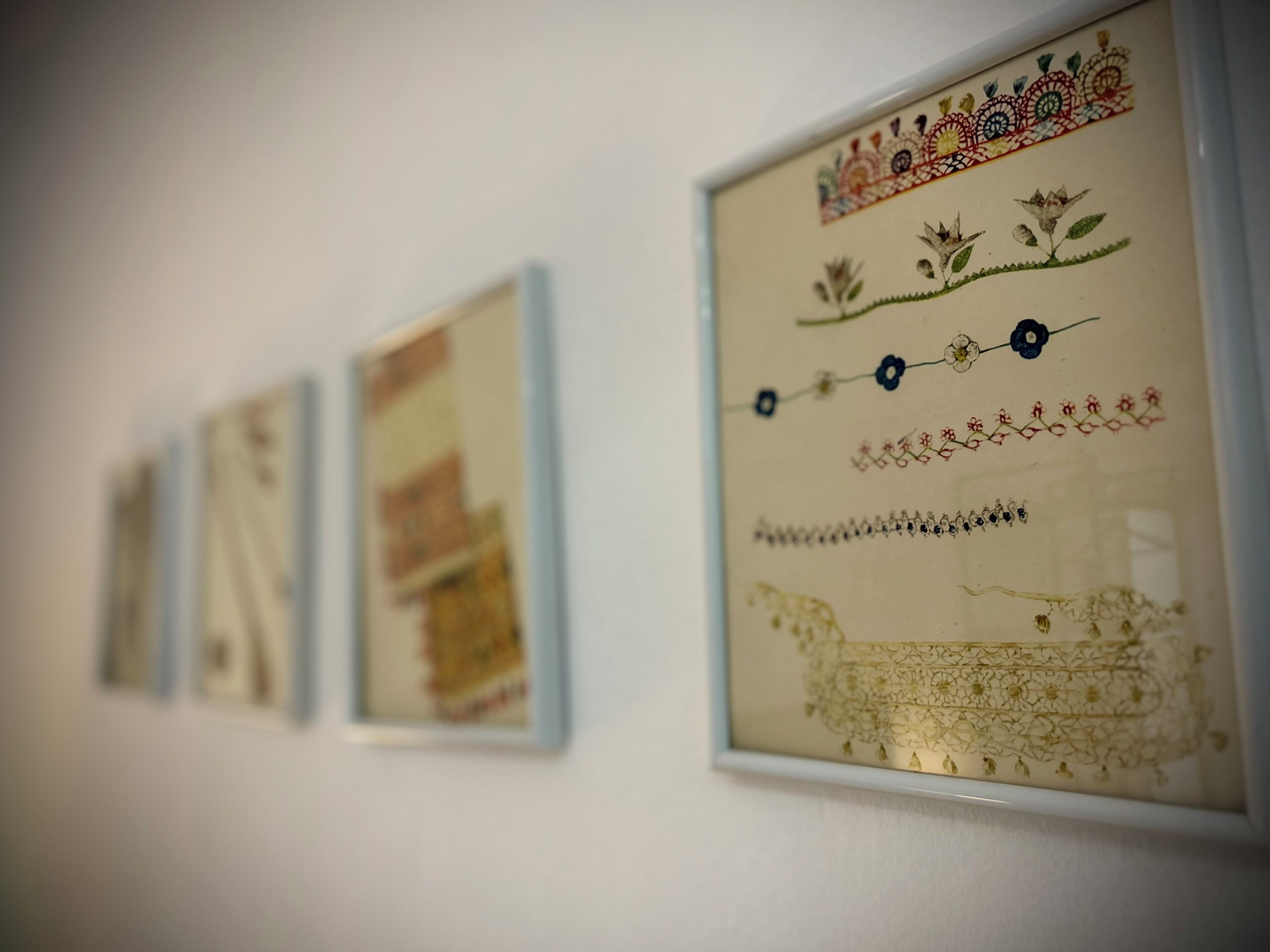 A series of framed artworks on a wall.