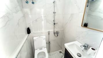 Ein Badezimmer mit Toilette, Dusche und Waschbecken.