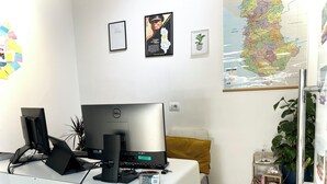 A modern office space with a Dell desktop computer, a yellow cushion, a map on the wall, and a potted plant. - Tirana Budget Retreat Hotel (Tirana)