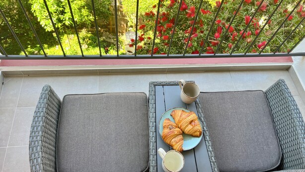 A balcony with wicker furniture, a plate with croissants, and a cup of coffee. - Rosoglio Poreč 300m from sea, new apartment 2024 (Poreč)