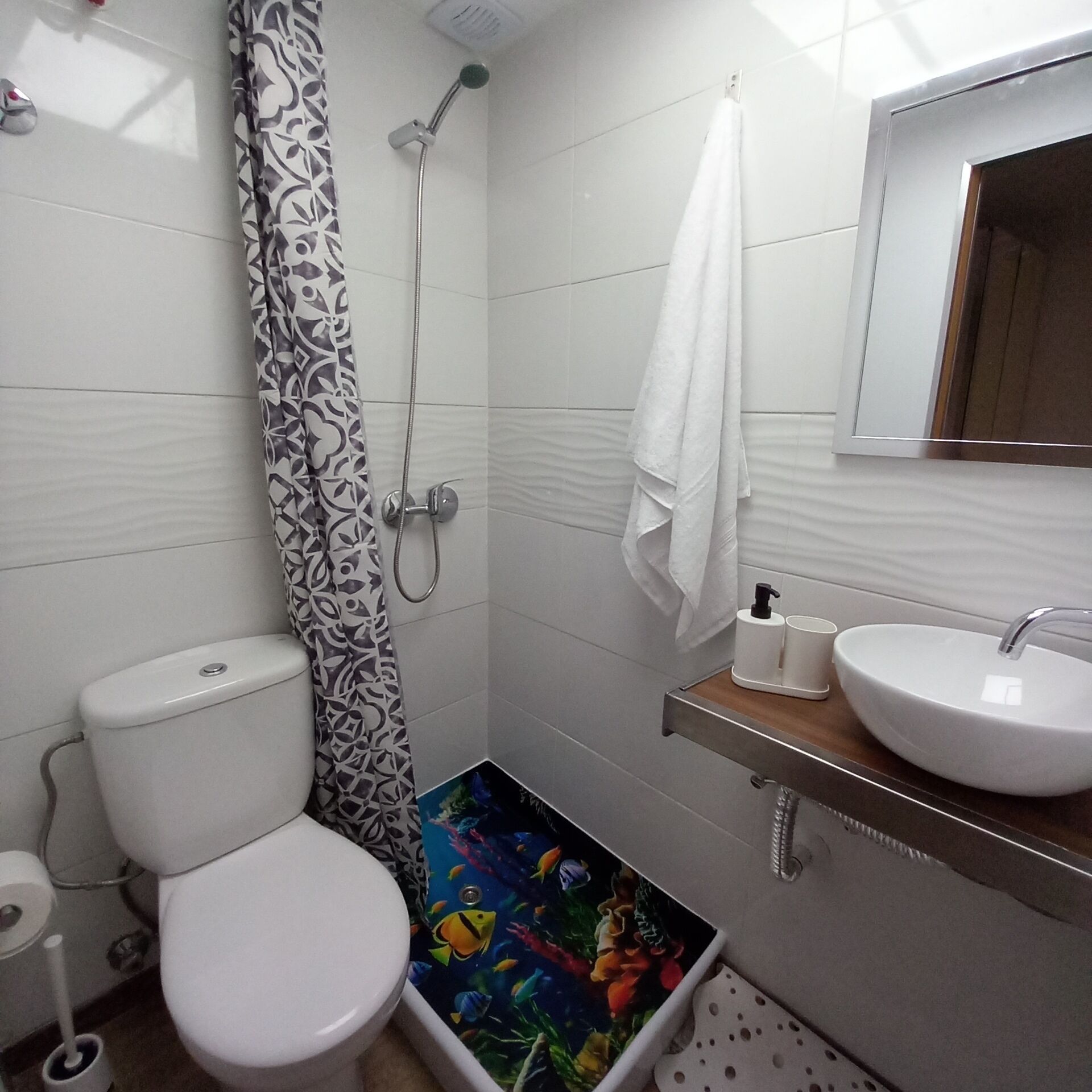 Un baño con inodoro, ducha y lavamanos.