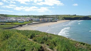 Une ville côtière dotée d’une plage de sable, d’une promenade et de bâtiments qui bordent le littoral.