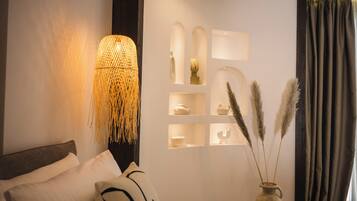 A modern bedroom with a bed, a wall-mounted lamp, and decorative shelves.