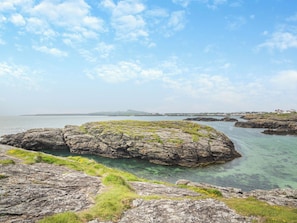 A coastal landscape with rocky formations and clear water.