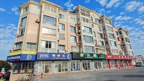 A multi-story building with various storefronts on the ground floor, including a pharmacy, a seafood restaurant, and a restaurant. - Dongshan Haizhiyuan Apartment (Dongshan County)