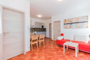 A compact living space with a kitchen, dining area, and a red sofa. - App. 2 - Apartment House Viric /holiday-vir/ (Vir)