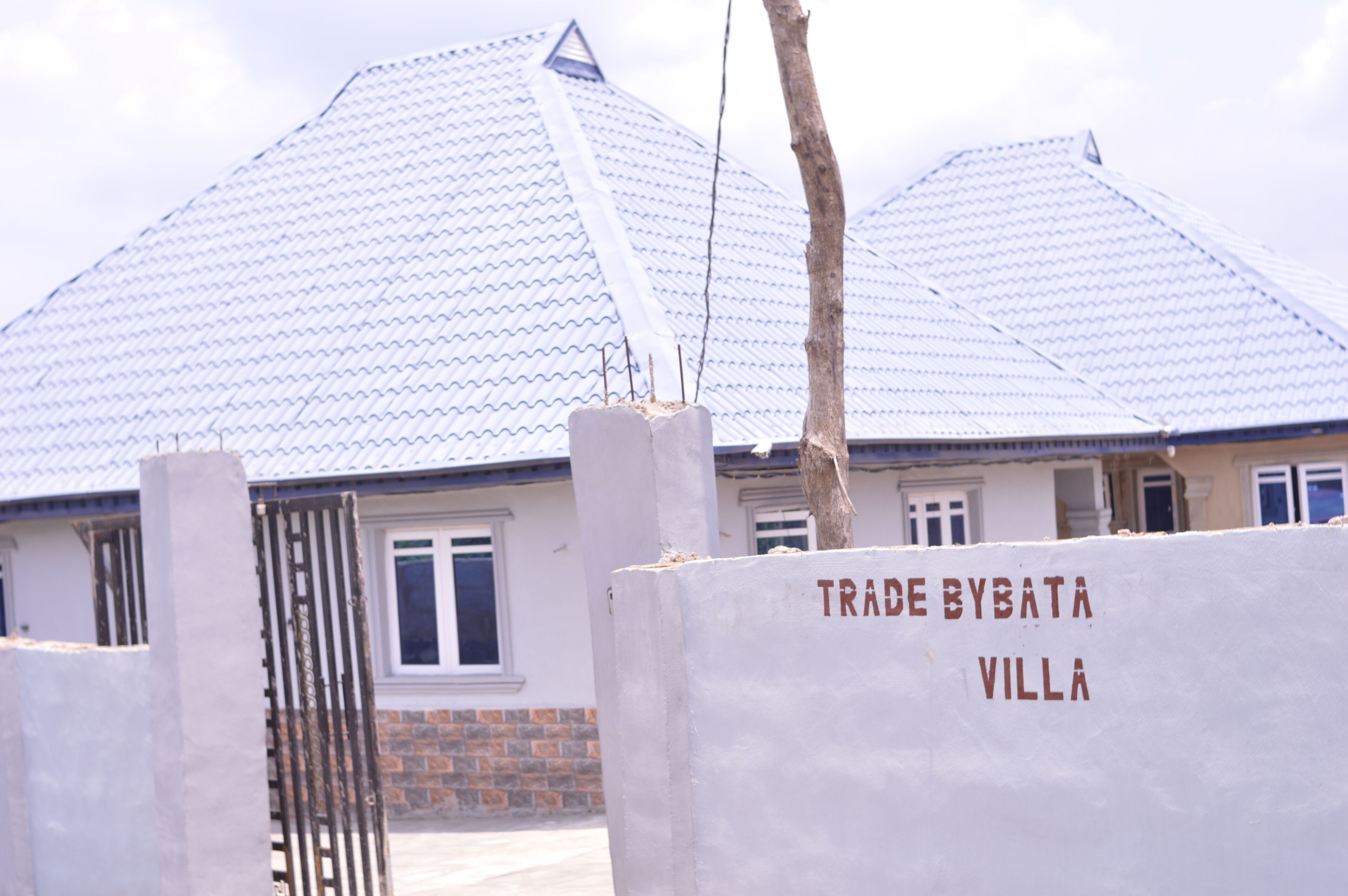 A villa with a tiled roof and a gated entrance.