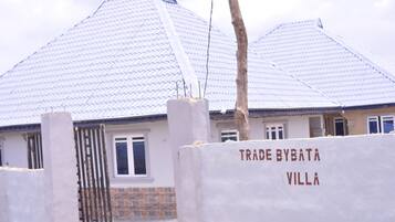A villa with a tiled roof and a gated entrance.