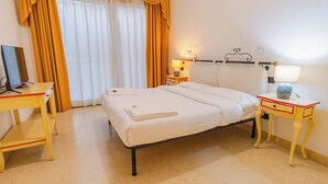 A hotel room with a bed, a desk, a lamp, and a nightstand. - 02 Relais du Lac Village (Desenzano del Garda)