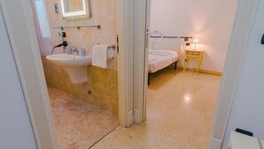 Une salle de bain équipée d’un lavabo, d’un miroir et d’un porte-serviettes.