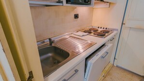 Une cuisine équipée d’un évier en acier inoxydable, d’une cuisinière et d’un lave-vaisselle.
