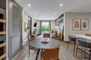 A modern dining area with a round table, wicker chairs, and a view of the outdoors. - Luxury Nashville Getaway 6 Min to Broadway (Nashville)