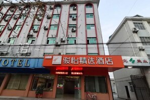 Een hotel met een opvallend rood bord en meerdere airconditioners op de gevel.